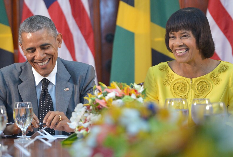 US President Barack Obama (L) shares a laugh with Jamaica's Prime Minister Portia Simpson Miller during a meeting at Jamaica House on April 9, 2015 in Kingston. AFP PHOTO/ MANDEL NGAN        (Photo credit should read MANDEL NGAN/AFP/Getty Images)