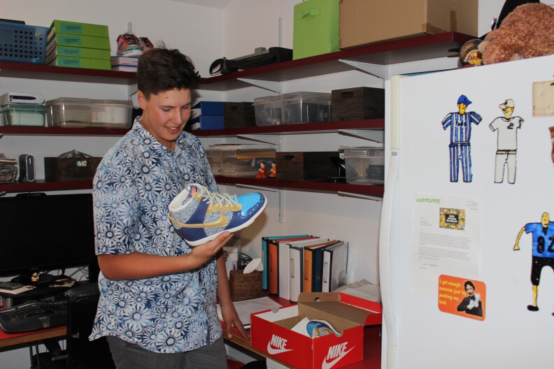 Wes Burton shows off the first pair of sneakers he ever painted, a gift for his mom Sabrina.