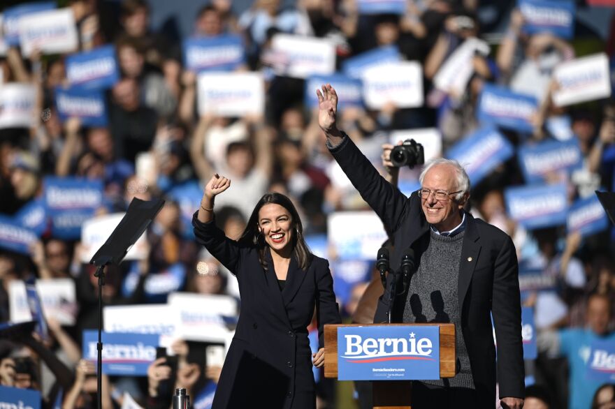2020 Democratic presidential hopeful US Senator Bernie Sanders (D-VT) and representative Alexandria Ocasio-Cortez (D-NY) wave to a crowd of supporters during a campaign rally on October 19, 2019  in New York City. (Photo by Johannes EISELE / AFP) (Photo by JOHANNES EISELE/AFP via Getty Images)