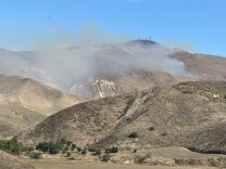 Fire smoke emerging from mountain ranges 
