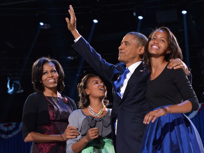 US President Barack Obama, First Lady Michelle and daughters Sasha (L) and Malia (R) wave to supporters on election night in Chicago on November 6, 2012. Obama swept to re-election, forging history again by transcending a slow economic recovery and the high unemployment which haunted his first term to beat Republican Mitt Romney