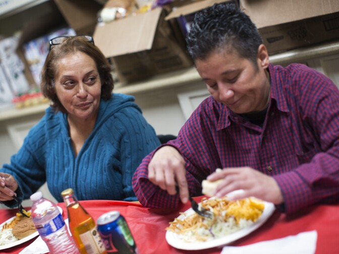 Elizabeth Montecino, left, and Zonia Sotelo eat dinner at All Saints' Episcopal Church in Highland Park on Tuesday night, Dec. 22, 2015. Montecino and Sotelo have been friends for about 10 months.