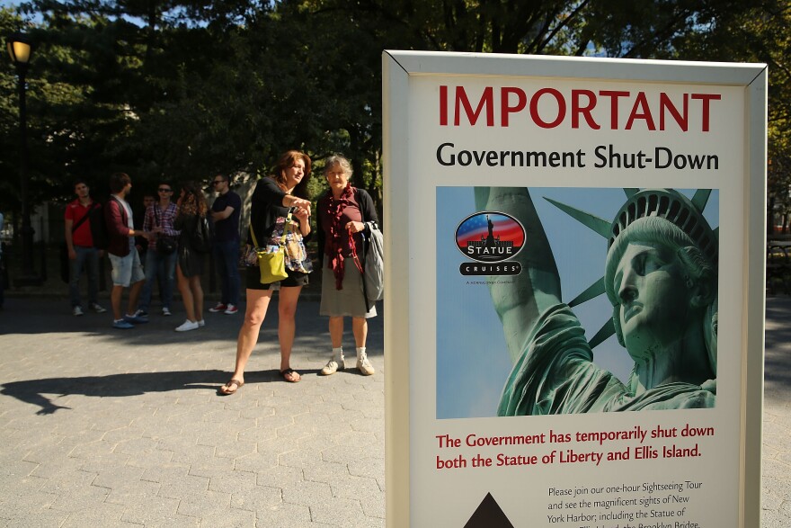 People look at a sign for informing that the Statue of Liberty is closed due to the government shutdown in Battery Park on October 1, 2013 in New York City. Federal museums and parks across the nation are closed starting today due to a government shutdown for the first time in nearly two decades. The Dow Jones industrial average, the S&P 500 and the Nasdaq all rose slightly higher in early trading Tuesday morning. 