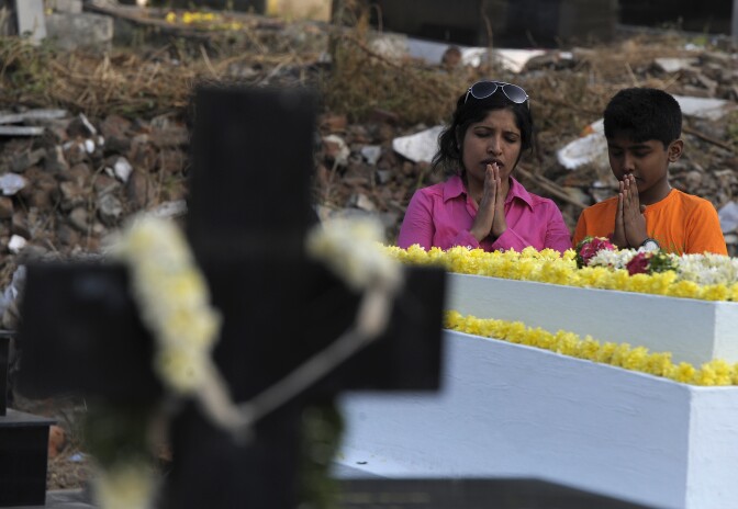Indian Catholics offer prayers at the graves of their family members at a cemetery during All Souls Day in Hyderabad on November 2, 2016.