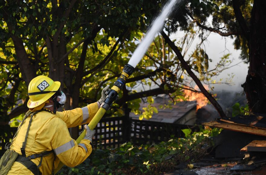 A firefighter battles the Skirball Fire in Bel Air, California on December 6, 2017.