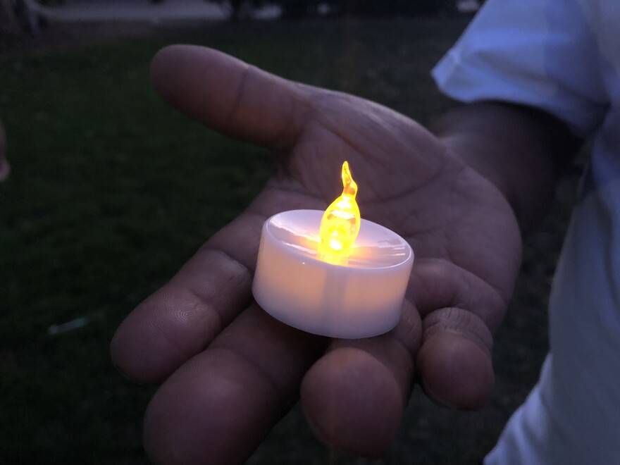 One of the over 100 people gathered at the vigil holds a candle in honor of the victims of the El Paso shooting.