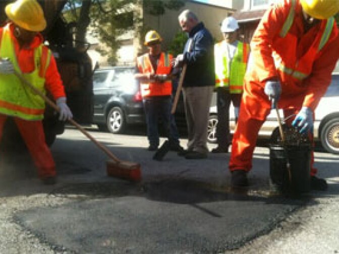 Los Angeles street services crew members Joyce Robinson and Ralph Jackson repair a pothole on Reno Street 