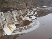 Water and mud cover Pacific Coast Highway north of Deer Creek Road after Sunday's rains forced its closure. 