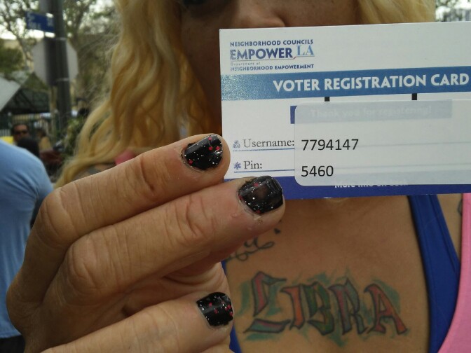 Keyama L. Bryant, a long-time resident of Skid Row, holds up her voter registration card for a special election held on Thursday, April 6, 2017. 