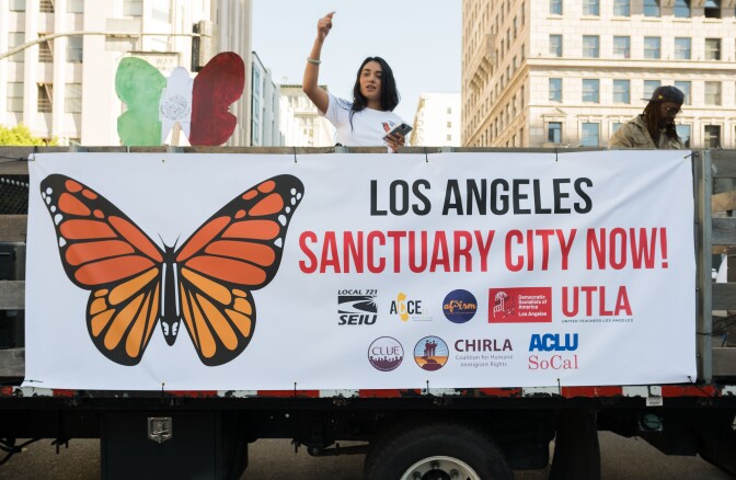 A person on a truck with a sign in front.