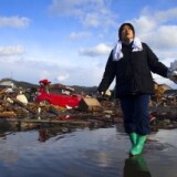 Chieko Chiba walks through the rubble after going to see her destroyed home March 16, 2011 in Kesennuma, Miyagi province, Japan.