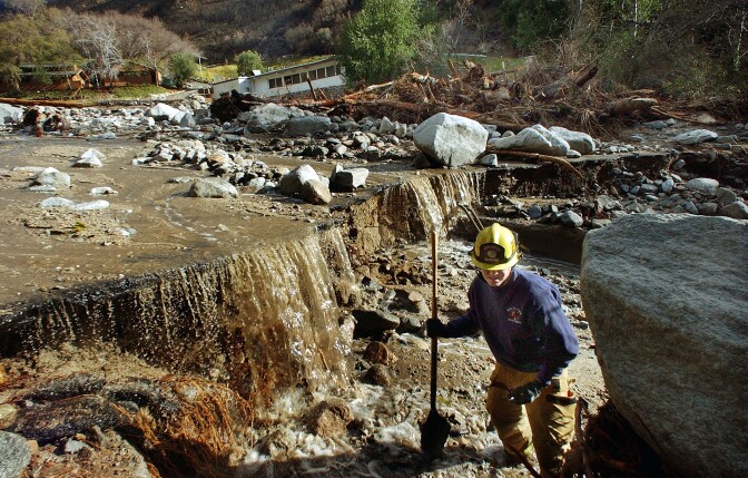 WATERMAN CANYON - DECEMBER 26:  Rialto Firefighter Dave Denman searchs for victims after a mudslide December 26, 2003 in Waterman Canyon, California. The mudslide which killed at least four, and left 12 missing was caused by heavy rains.  (Photo by Richard Hartog-Pool/Getty Images)