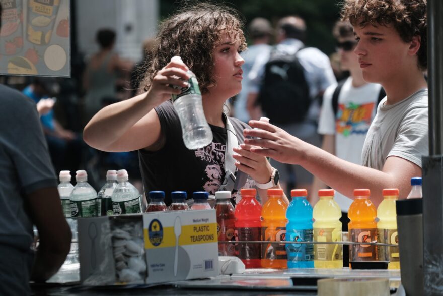 A woman buys a bottle of water during a heat wave in Central Park in New York City.