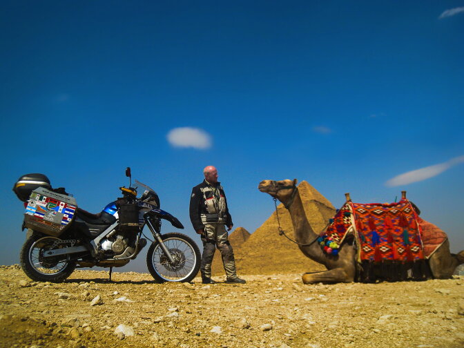 At the Great Pyramids of Giza south of Cairo, Allan Karl contemplates whether he might be better served on a camel than an motorcycle while traveling in the Sahara. 