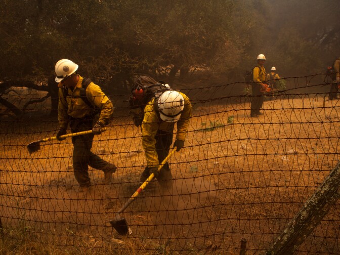 Firefighters clear vegetation near a home in Hidden Valley, Calif., on May 3, 2013.