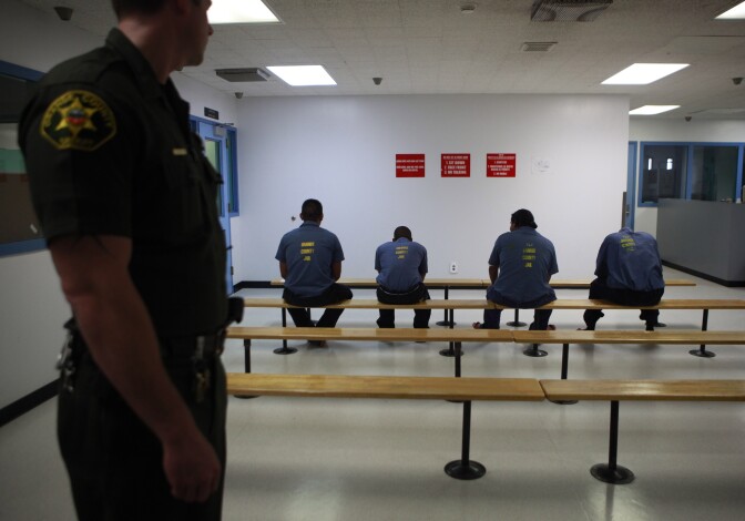 An Orange County Sheriff's deputy keeps a watch over a group of immigration detainees in the medical and dental care area at the Theo Lacy Facility in Orange, Calif., Tuesday, Sept. 28, 2010. Hundreds of detained immigrants are being transferred to Orange County jails, and more are on the way, under a deal with the federal government that would bring the cash-strapped Orange County Sheriff's Department up to $30 million a year, a newspaper reported Sunday. (AP Photo/Jae C. Hong)