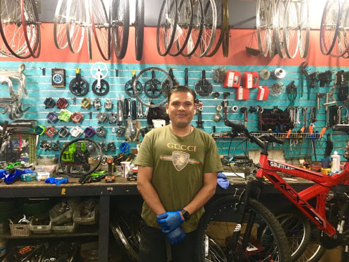 An image of a man posing in front his bike shop's work station in Van Nuys.