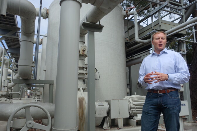 In this April 25, 2014 photo, Joshua Haggmark, interim resources manager for Santa Barbara, Calif., stands next to a desalination plant, which removes salt from ocean water, in Santa Barbara, Calif.  The city is considering restarting the plant as California withers in a drought.