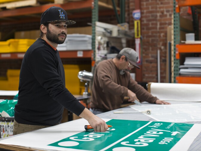 Eduardo Rivers helps weed out street signs for South El Monte on Friday, Jan. 9 at JCL Traffic in Los Angeles. The designs will then be adhered onto pieces of metal.
