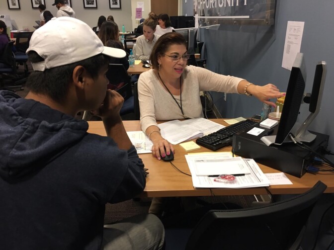 Aimee Meraz with Public Counsel in Los Angeles assists Cesar, 20, in filling out his application for renewal of Deferred Action for Childhood Arrivals, or DACA.