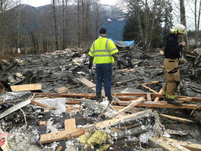 SNOHOMISH COUNTY, WASHINGTON - MARCH 22:  In this handout from the Washington State Patrol, emergency workers examine debris after a mudslide March 22, 2014 in Snohomish County, Washington. According to reports, 18 people are still missing after a mudslide killed three and injured another eight. The mudslide is said to measure a square mile and 15 feet deep in places.  (Photo by Washington State Patrol via Getty Images)