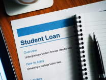 Document under a notebook with a letterhead reading "Student Loan"