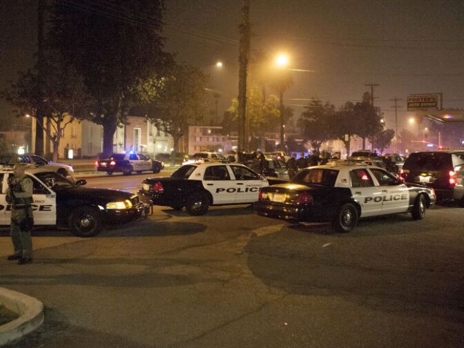 Police respond in Riverside, Calif., early Thursday morning, Feb. 7, 2013, after one officer was killed and another critically wounded in a shoot out with a murder suspect.  Police were searching for a former Los Angeles police officer sought for two weekend killings — and who threatened to kill police.   
