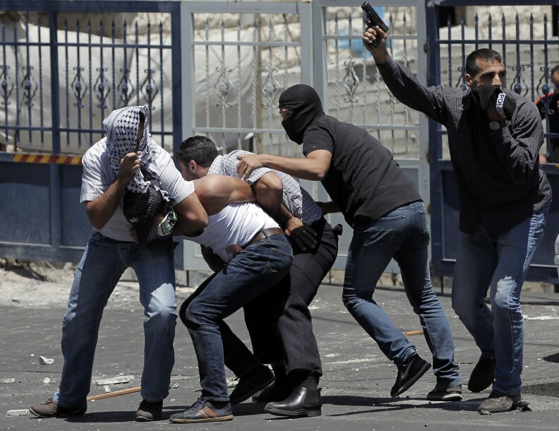 Israeli undercover policemen, one holding a gun, arrest a Palestinian (2ndL) during clashes following traditional Friday prayers near the Old City in East Jerusalem on July 25, 2014. Israeli security forces are on heightened alert after a Palestinian man was shot dead during a huge protest in the West Bank against Israel's military offensive in Gaza. Palestinian factions in the West Bank declared a 'Day of Rage' after the previous night's clashes around the West Bank and in some sectors of Israeli-annexed east Jerusalem.