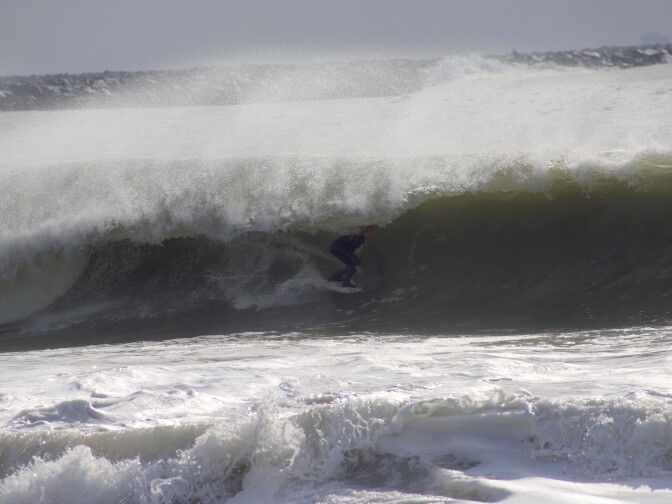 A female surfer with a wave curling over her head