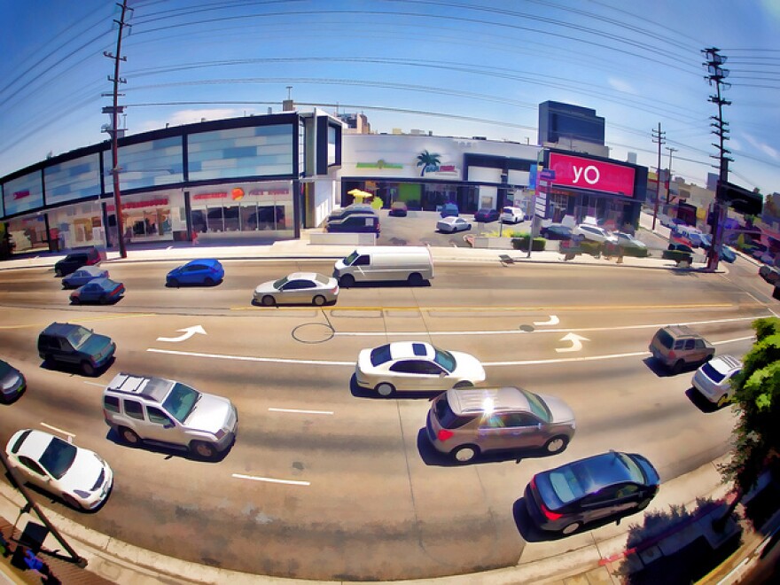 Cars are shown driving up and down La Cienega Boulevard during the day.