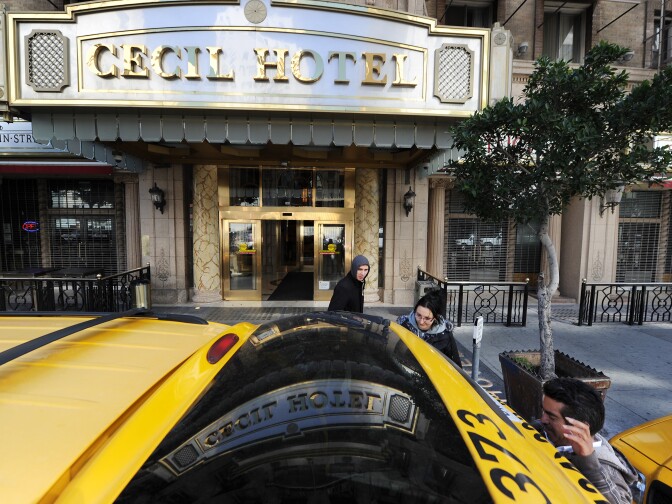 A taxi driver waits as British tourists Mike and Sabina Baugh, both 27, leave the Cecil Hotel on February 20, 2013, after the body of 21-year-old Canadian tourist Elisa Lam was found in a water tank on the roof of the hotel.