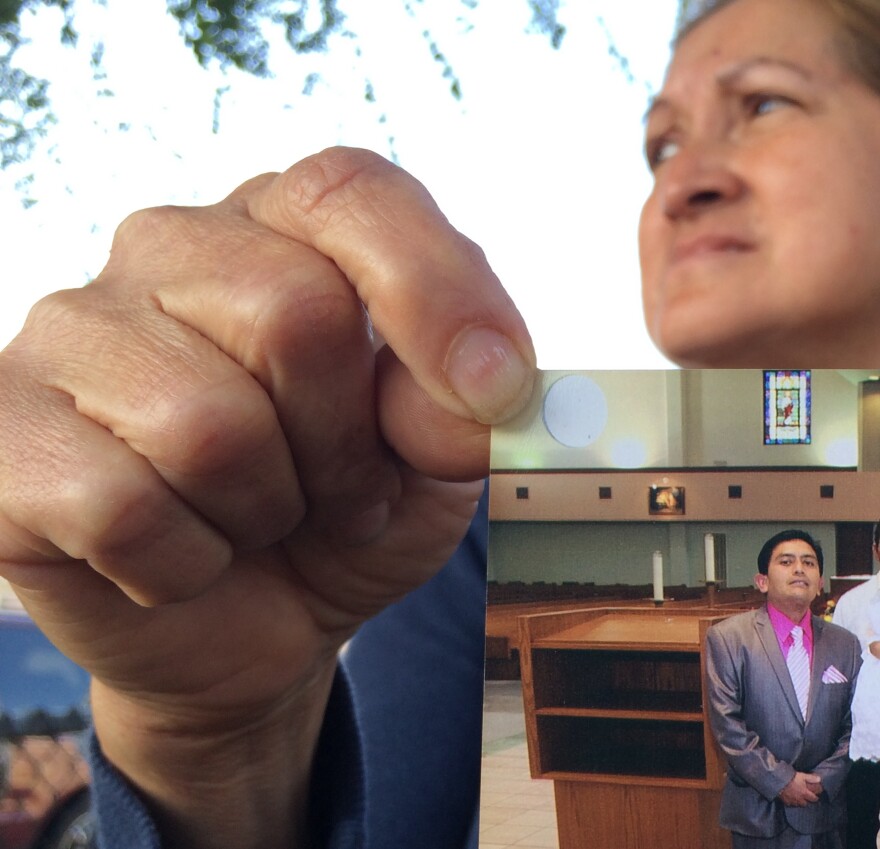 Neighbor Maria Sanchez holds a Jan. 29, 2012, photo of her neighbor Isidro Garcia at his daughter's third birthday at Bell Gardens church, while talking to the media on Wednesday, May, 21, 2014 in Bell Gardens, Calif. Garcia allegedly kidnapped a 15-year-old girl in Santa Ana in 2004 then repeatedly physically and sexually assaulted her over the course of 10 years.