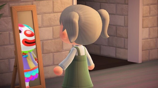 A video game character from "Animal Crossing" looks into a mirror and sees a cartoonish clown. 