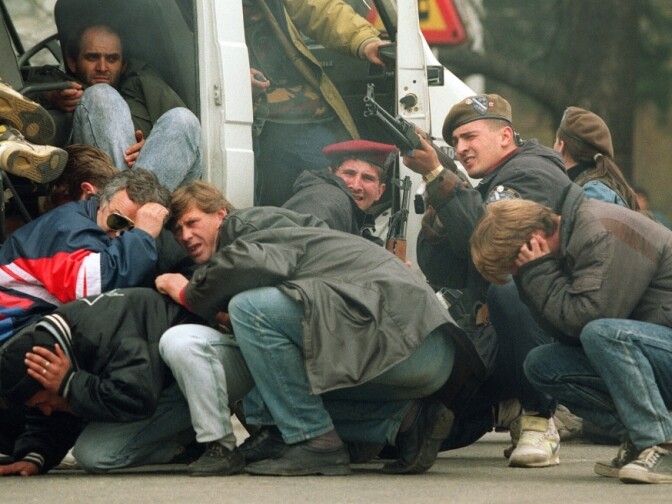 On April 6, 1992, a Bosnian special forces soldier (third from right) returns fire from Serbians opposed to Bosnian independence as civilians seek cover in downtown Sarajevo. The day marked the beginning of the 44-month siege of Sarajevo, which left 100,000 dead.