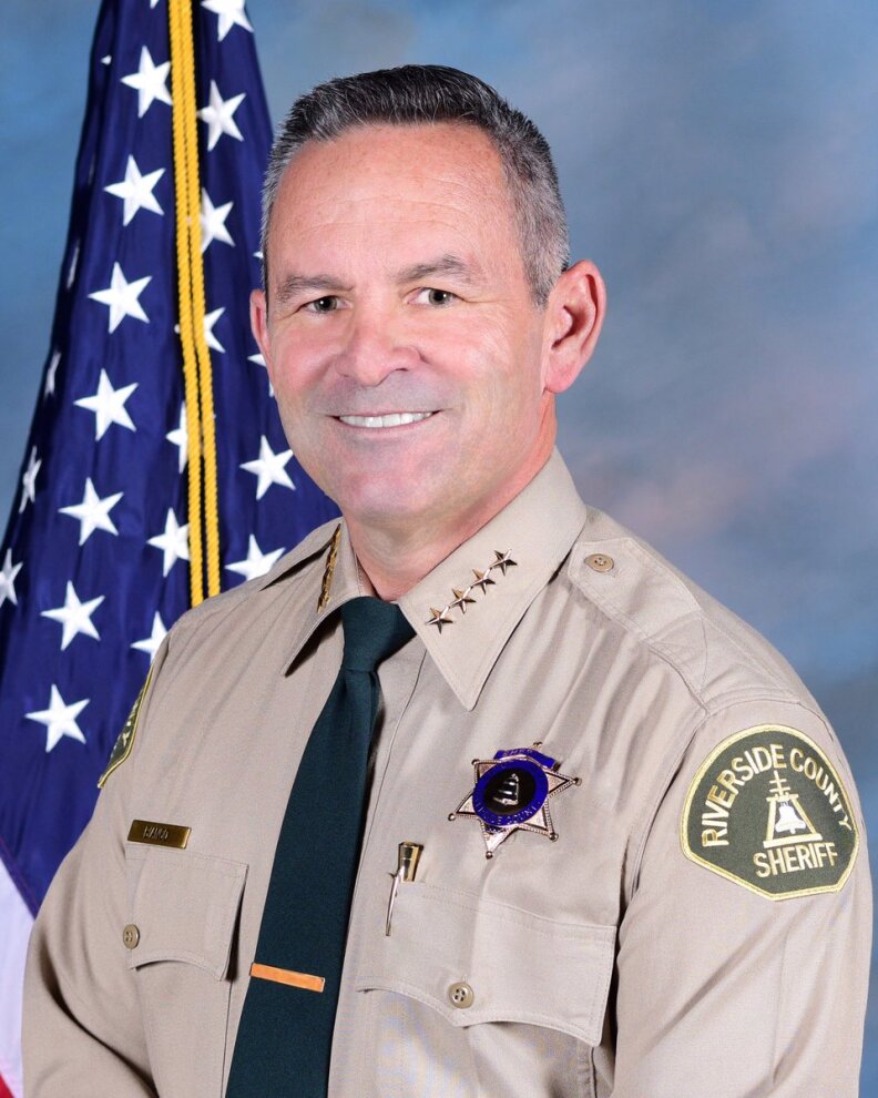 Riverside County Sheriff Chad Bianco poses for a portrait with an American flag in the background
