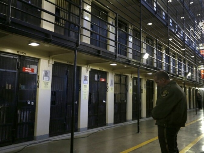 A guard stands watch over condemned inmates on death row at San Quentin State Prison. 