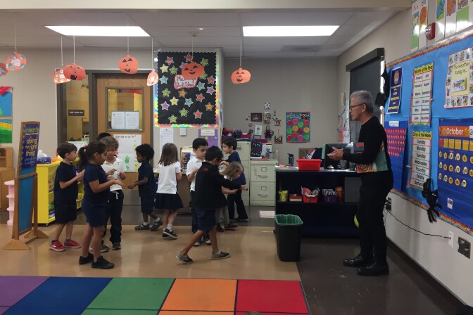 Music Center teaching artist Peter Kors instructs Willard Elementary students to move around a makeshift stage like tigers without running into each other. Kors says the activity teaches teamwork.