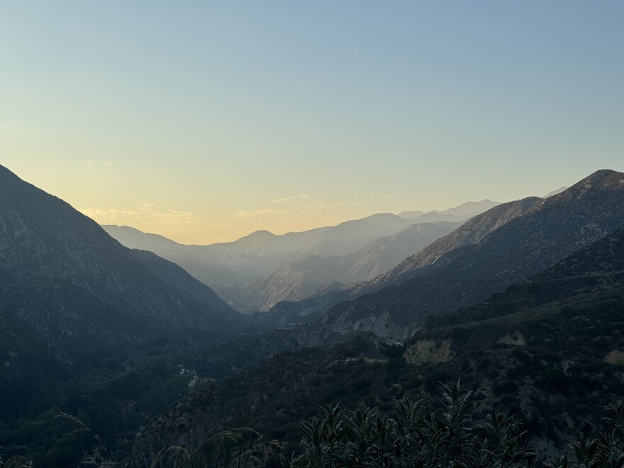 landscape photo of Big Tujunga Canyon at sunset. The mountains are case with a hazy golden glow.