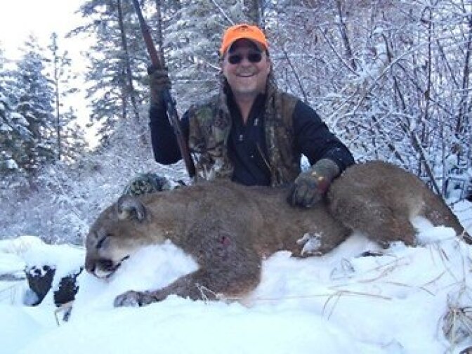 Richards poses with the now-dead mountain lion, which he later ate.