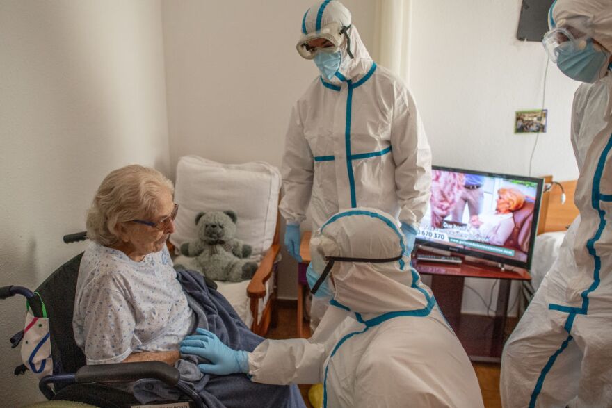PALLEJÀ, SPAIN - MAY 21: Primary health care nurse Jose Dominguez (C) and physician Joan Maria Farré (C) both in personal protective equipment (PPE) speak with Pilar Boxo who is in quarantine after being tested positive of COVID-19 during a monitoring visit to COVID19 patients at Yayo Toni on May 21, 2020 in Pallejà, Spain. As figures of deaths and infection rates are at their lowest since the start of the outbreak in Spain, the primary health care network will be crucial for filtering and monitoring COVID-19 patients, in order to protect Spanish hospitals from becoming over-crowded. This task will be especially intense across Spain's nursing homes, where more than 18,000 elderly people have died due to the Coronavirus  (COVID-19) pandemic. (Photo by David Ramos/Getty Images)
