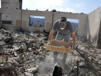 Gavin Floyd sifts through the wreckage of a dormitory destroyed in the Thomas Fire at the Ojai Valley School's Upper Campus on Dec. 20, 2017.