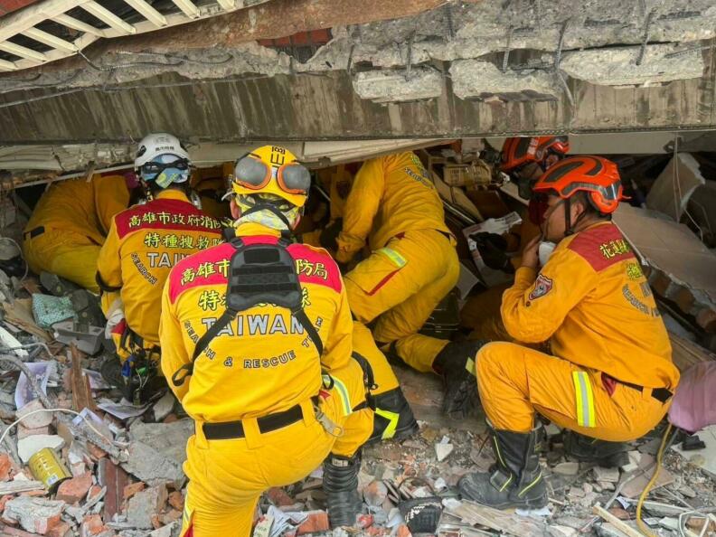 People in all yellow work under a collapsed structure.