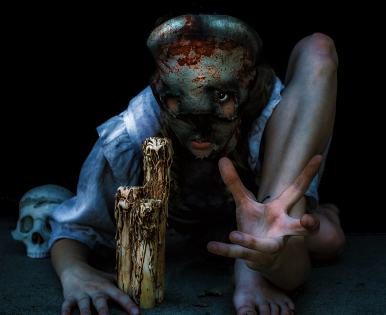 a human in a creepy, bloody mask crawls toward the camera