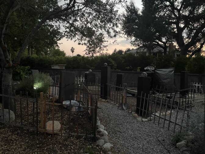 A front yar with tombstones and metal fences installed for Halloween