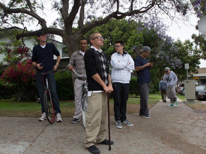 People in Santa Monica watch firefighters work on a house where two men were found dead in a burned home on June 7th, 2013.