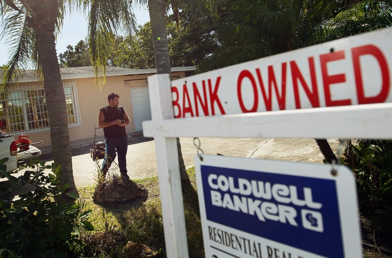 File: Renzo Salazar maintains the yard around a foreclosed home after the bank hired him to keep the home from falling into complete dilapidation on November 10, 2011 in Miami, Florida.