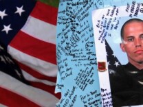 People leave messages for slain police officer Ryan Bonaminio at a makeshift memorial at Fairmount Park in Riverside. 