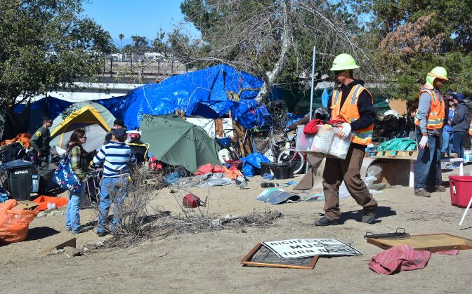 County workers clear and raze a homeless encampment beside the Santa Ana River on February 20, 2018 in Anaheim, California.
Officials in Orange County began moving homeless transients out of the homeless tent encampments to shelters or motels as part of the settlement worked out by homeless advocates and the county under supervision of a federal court judge. / AFP PHOTO / Frederic J. BROWN        (Photo credit should read FREDERIC J. BROWN/AFP/Getty Images)