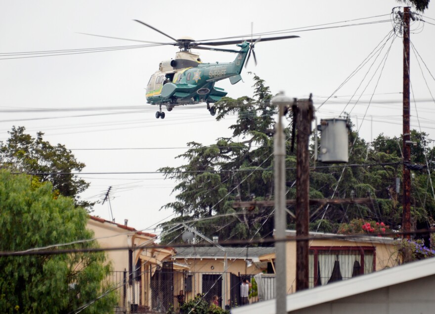 A Los Angeles County Sheriff's SWAT team  helicopter flies low over homes in the search zone during a massive manhunt for a suspect who attempted to kill two LAPD detectives on June 25, 2013 in Los Angeles, California. 