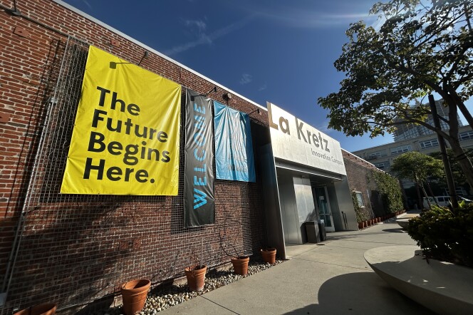 A wide angle shot of the outside of a brick building with a large yellow sign that reads "The future begins here." 